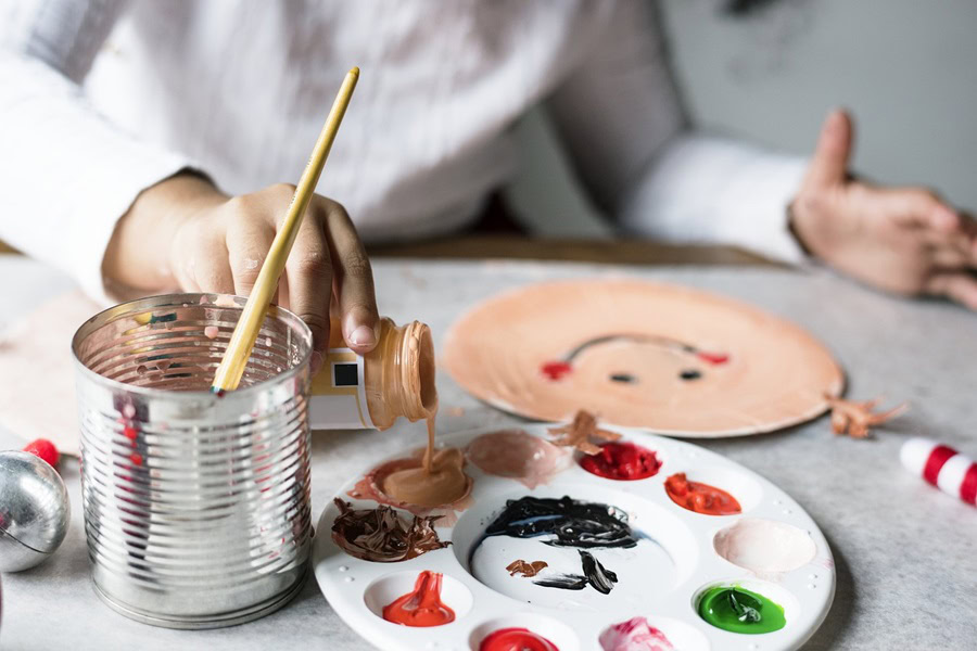 Halloween Crafts for Toddlers a Young Girl Sitting at a Table Painting a Smiley Face on a Paper Plate