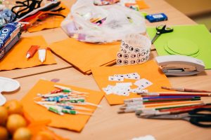 Halloween Crafts for Toddlers a Craft Table Filled with Orange and Green Construction Paper, Spooky Eye Stickers and Paint Brushes