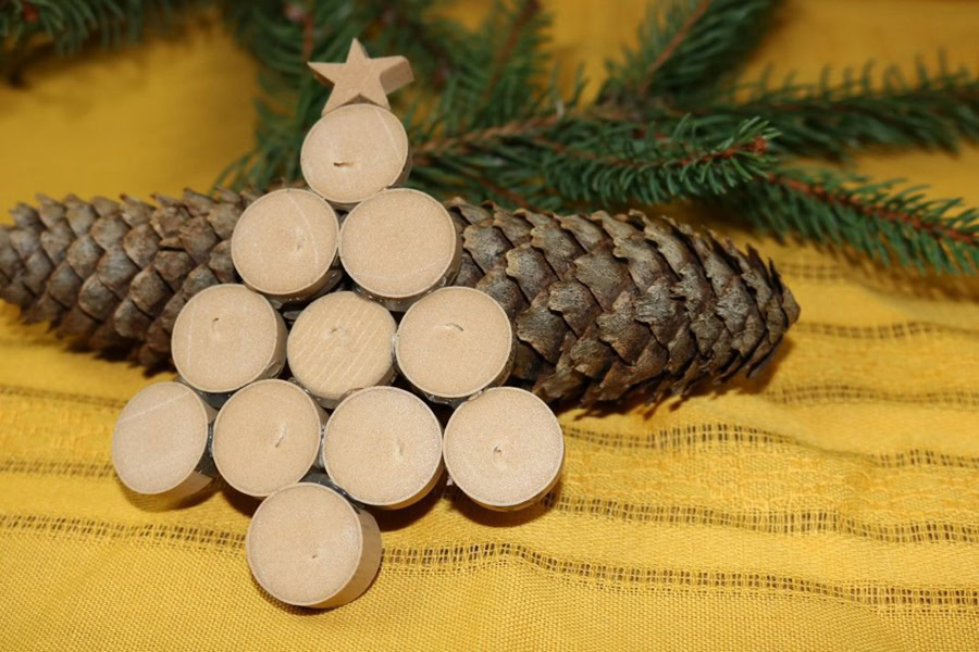 Easy DIY Wine Cork Ornament Close Up of Wine Cork Ornament Lying Against a Pie Cone with a Pine Tree Branch in the Back