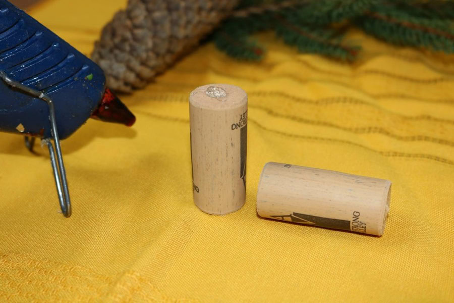 Easy DIY Wine Cork Ornament Close Up of Two Wine Corks Next to a Hot Glue Gun 