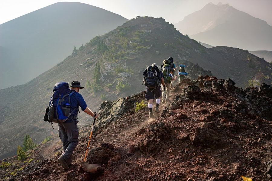 Funny Backpacking Quotes a Group of People Hiking Along a Mountain Ridge