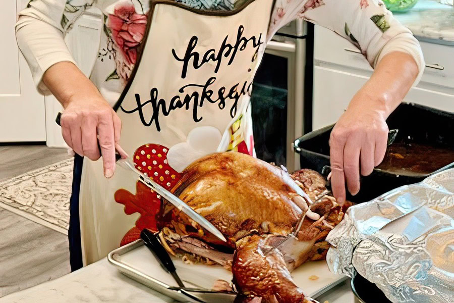 Sausage Stuffing Recipes for Thanksgiving Close Up of a Person Carving a Turkey in a Kitchen