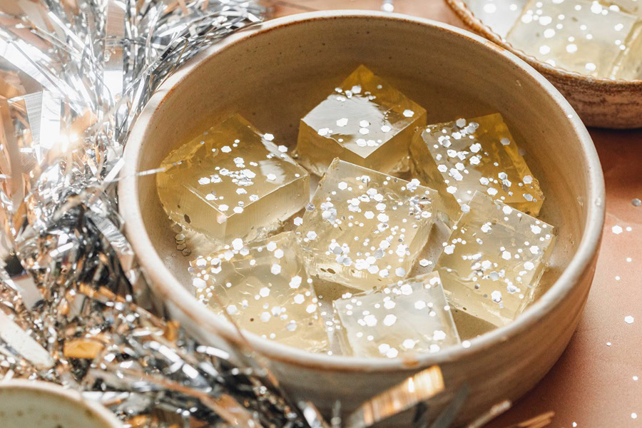 Champagne Jello Shots Recipe Close Up of a Bowl of Jello Shots With Silver Party Decorations Around the Bowl