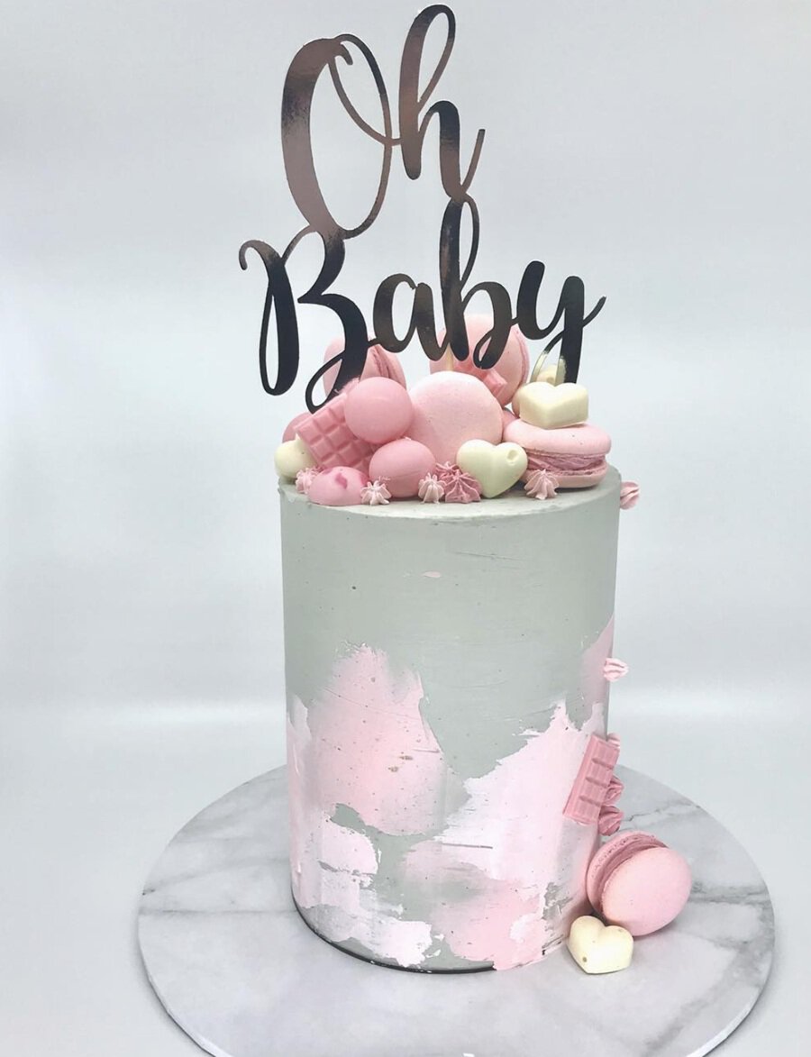 Baby Shower Cakes for Girls a Tall White Cake with Pink Smudges Toward The Bottom and French Macarons On Top