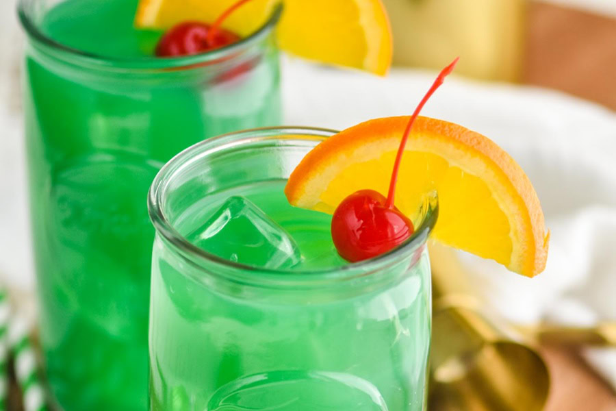 Green Cocktails for St Patricks Day Two Green Cocktails Garnished with an Orange Wedge and Cherry