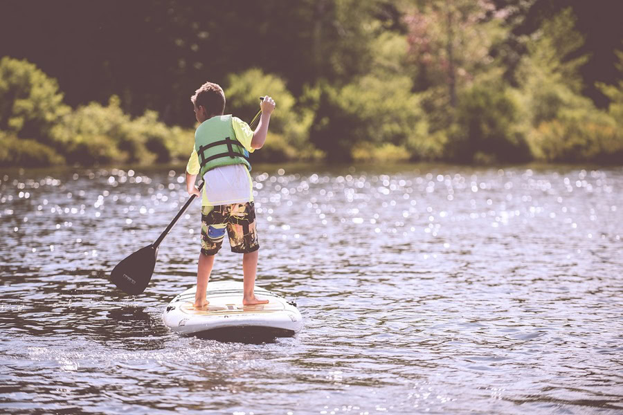 Motivational Quotes for Kids a Young Boy Paddle Boarding on a Lake While Wearing a Life Vest
