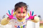 Motivational Quotes for Kids a Young Girl Holding Her Hands Up Covered in Finger Paint with Finger Lines of Paint on Her Face