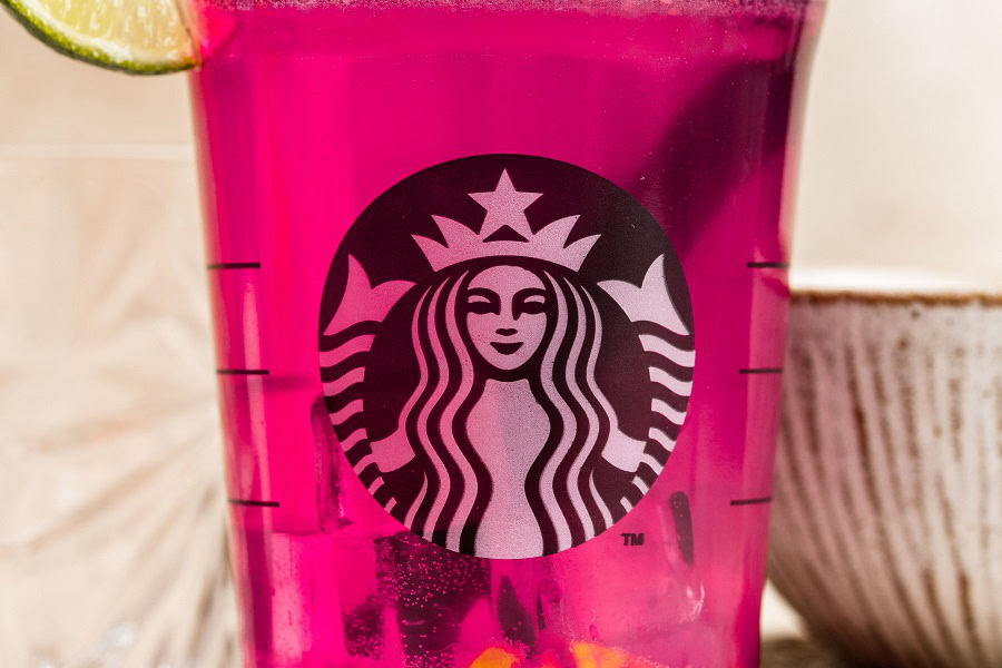 Starbucks Mango Dragon Fruit Refresher Recipe Close Up of a Starbucks Cup with a Pink Drink Inside