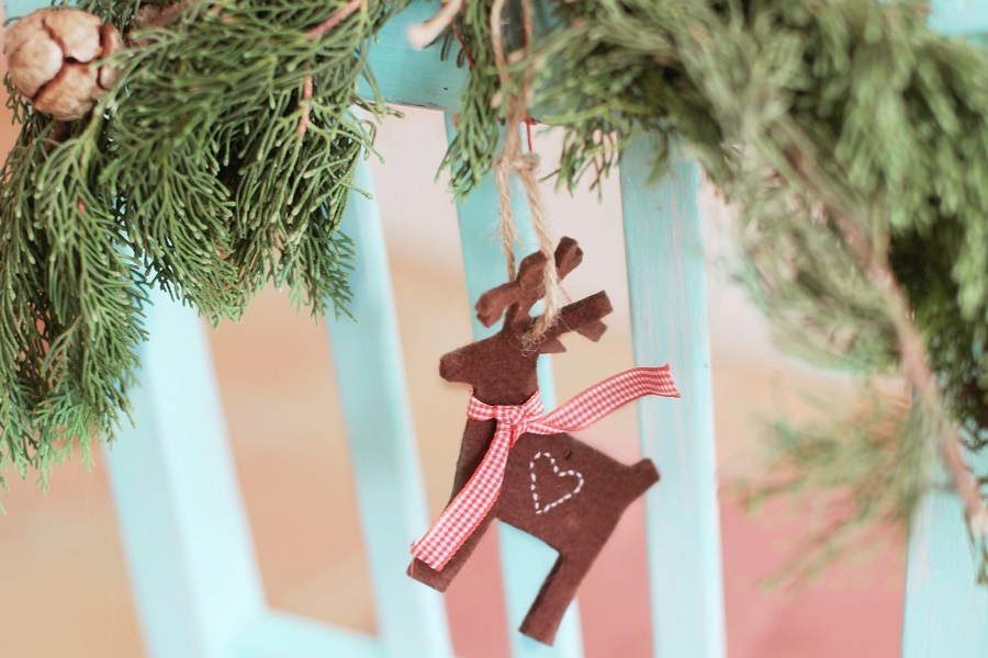 Christmas Party Food for Kids a Reindeer Ornament Hanging From Garland on a Fence