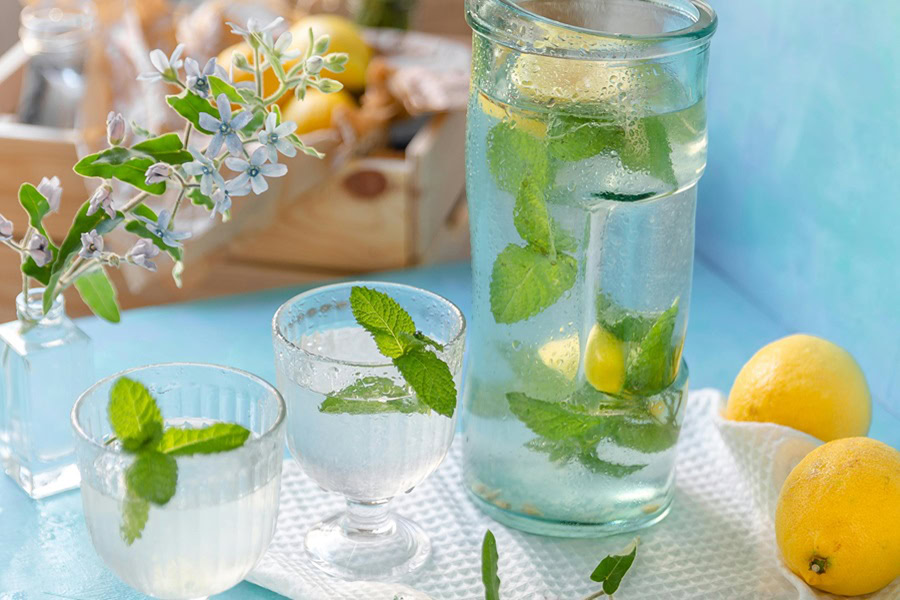 How to Make Batch Cocktails Two Small Cocktails Next to a Pitcher Filled with Cocktail