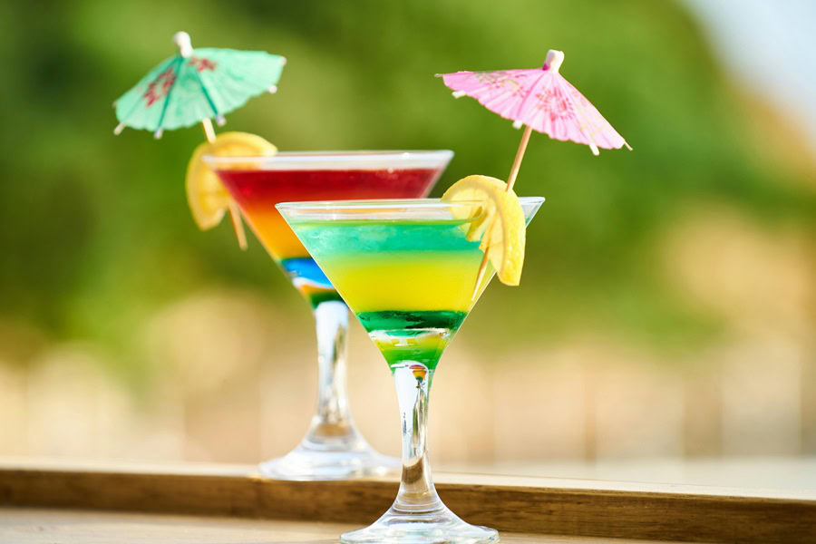 How to Make Batch Cocktails Two Martini Glasses Garnished with a Lemon Wedge and Two Small Cocktail Umbrellas