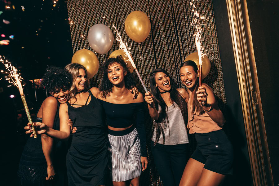 Pitcher Cocktails a Group of Women Posing for a Group Photo at a Party with Gold and Silver Balloons