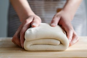 Puff Pastry Appetizer Recipes Close Up of a Person Folding Puff Pastry Dough on a Floured Surface
