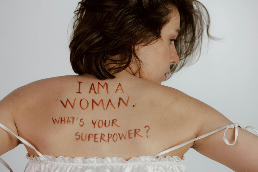 Inspiring Body Positivity Quotes a Womans Back with "I am a Woman. What's Your Superpower?" Written on it