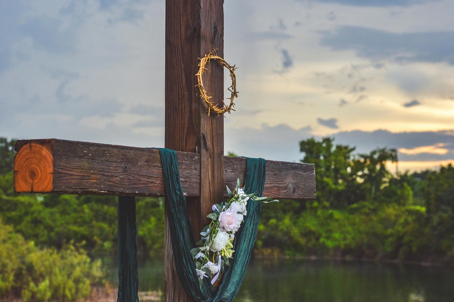 Christian Quotes for Easter Sunday Close Up of a Crucifix with a Crown of Thorns and Flowers Hanging From the Cross