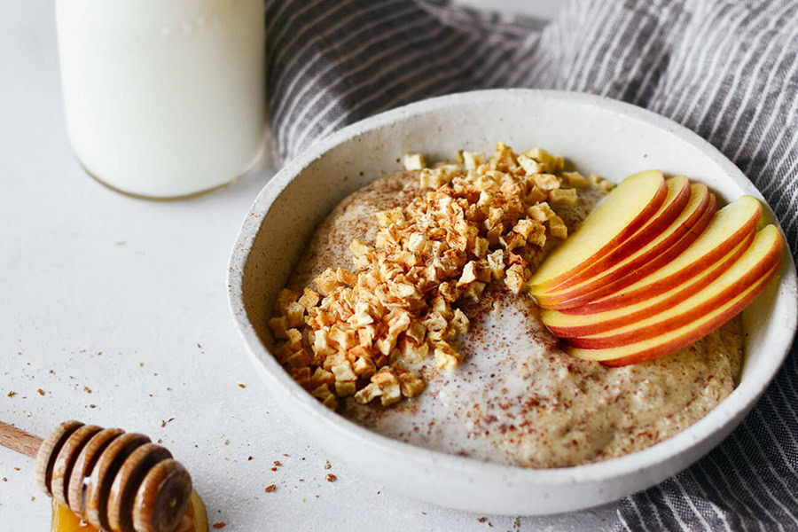 Whole30 Breakfast Recipes a Bowl of Hot Cereal with Apple Slices and Honey Next to a Glass of Milk