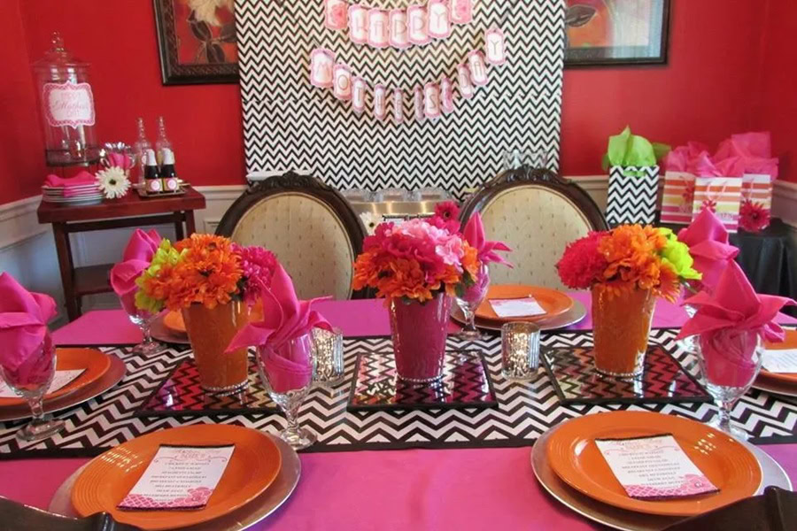 Mother&rsquo;s Day Brunch Decor Ideas a Table with a Pink Tablecloth, Pink Flower Centerpieces, and Pink Plates