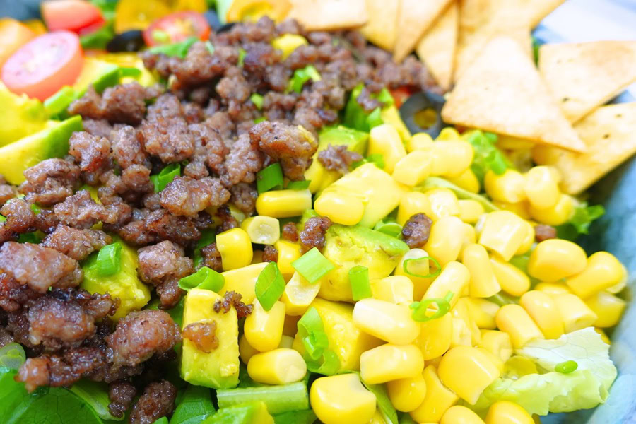 Taco Salad with Cilantro Lime Dressing Close Up of Ground Beef, Corn, Diced Tomatoes, and Tortilla Strips in a Taco Salad with Cilantro Lime Dressing