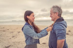 Father's Day Quotes from a Daughter's Heart a Teary Eyed Daughter Reaching Her Arms Out to Grab Her Father's Sweater, Standing Together on a Beach