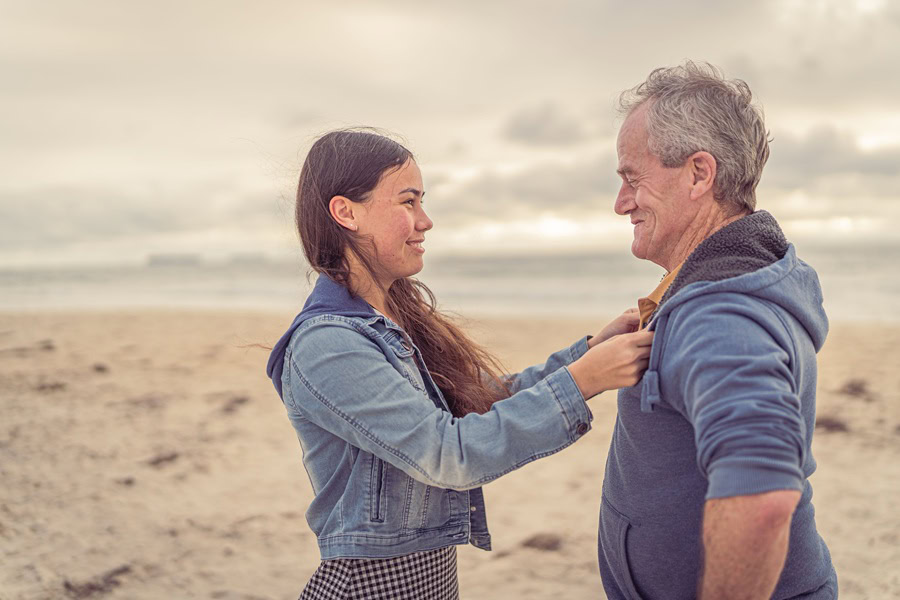 Father's Day Quotes from a Daughter's Heart a Teary Eyed Daughter Reaching Her Arms Out to Grab Her Father's Sweater, Standing Together on a Beach