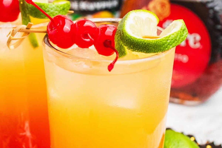 Tequila Drinks That Aren&rsquo;t Margaritas Mexican Sunset Cocktail Garnished with Cherries and a Lime Wedge