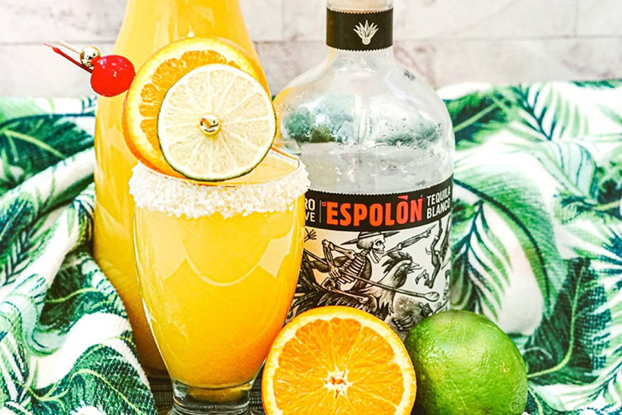 Tequila Drinks That Aren&rsquo;t Margaritas Tequila Screwdriver Garnished with an Orange Slice and a Lime Slice Mixer Bottle Behind it and Juice