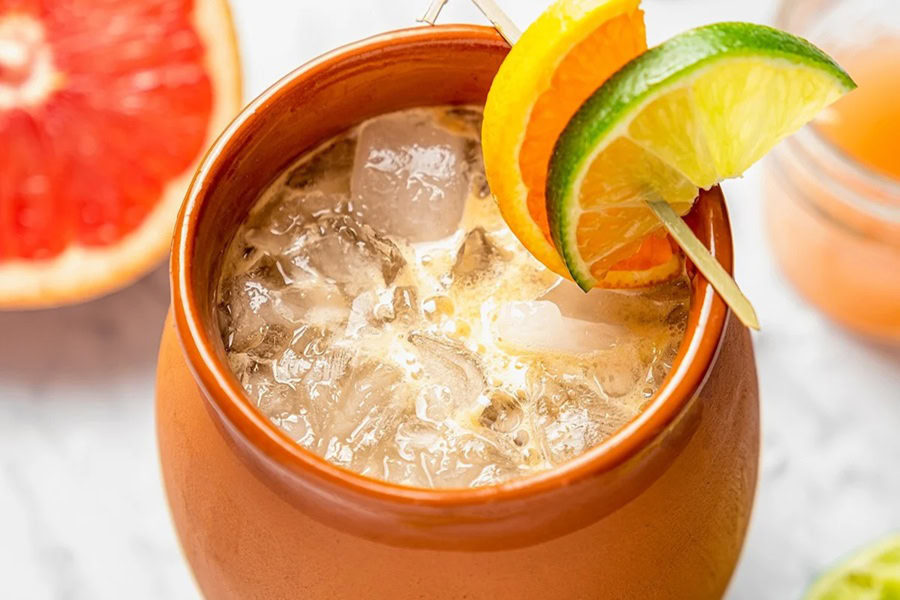 Tequila Drinks That Aren&rsquo;t Margaritas Cantaritos in a Clay Cup Garnished with a Lime Wedge and an Orange Wedge
