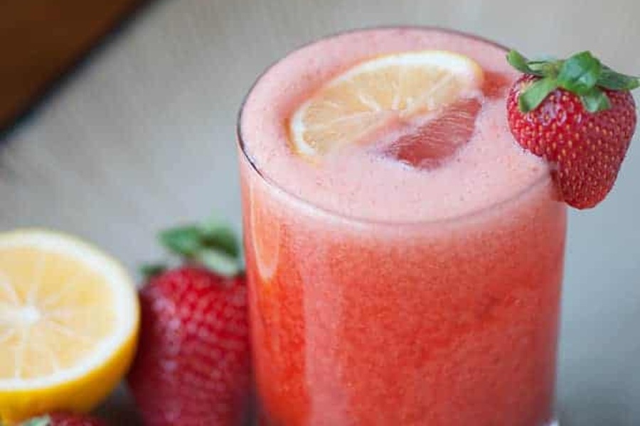 Whiskey Drinks for Summer Strawberry Lemonade Whiskey Sour in a Glass Garnished with a Strawberry
