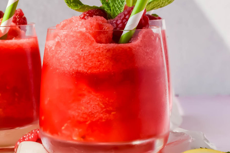 Backyard BBQ Drinks for an Outdoor Party Frozen Raspberry Lemonade Refresher in a Glass with a Straw