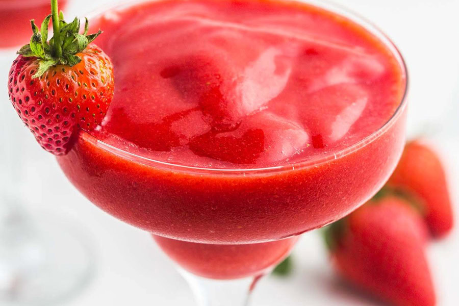 Backyard BBQ Drinks for an Outdoor Party Close Up of Blended Strawberry Daiquiri Garnished with a Strawberry