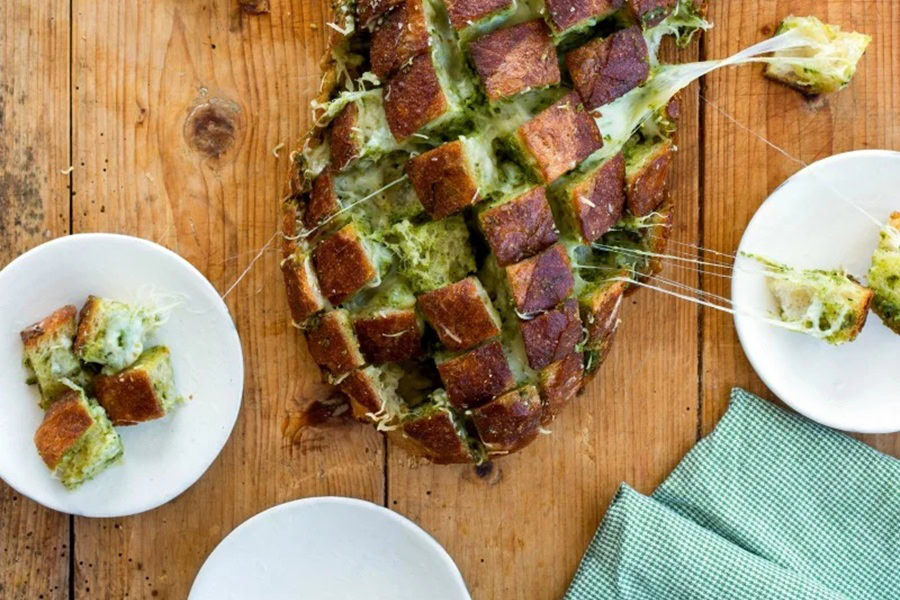 Best Side Dishes for a BBQ Cheesy Pull-Apart Pesto Bread on a Wooden Surface with Plates 