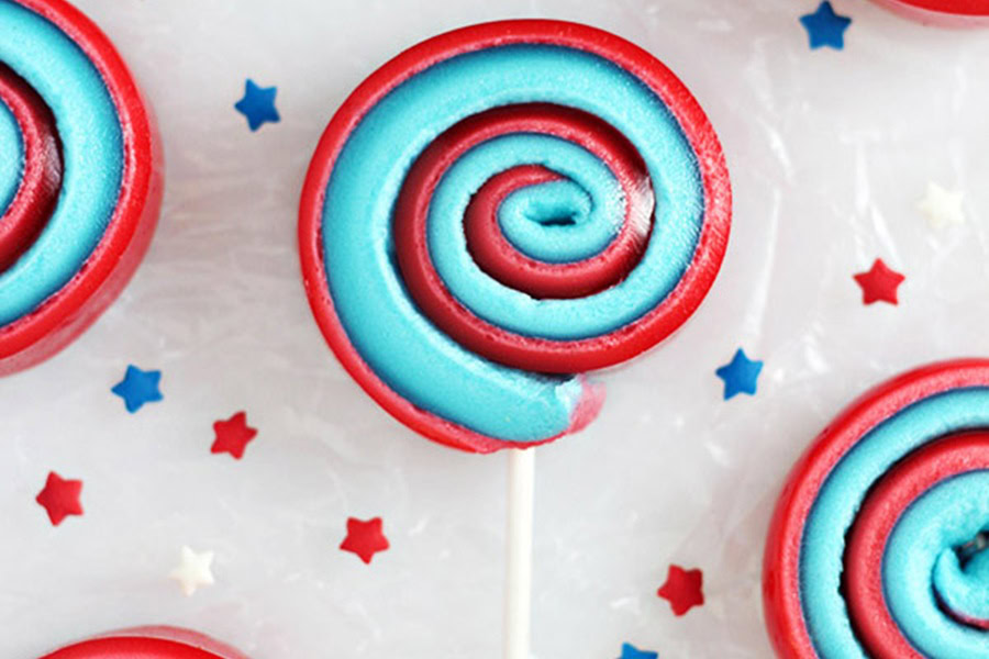 Red White and Blue Desserts 4th of July Marshmallow Pinwheels with Red, White, and Blue Star Sprinkles Scattered Around