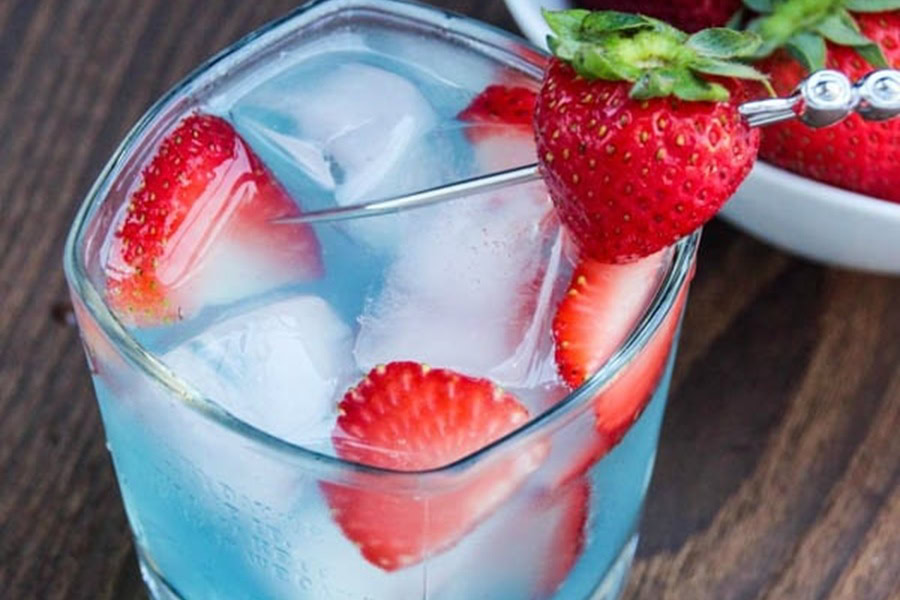 Red White and Blue Drink Recipes with Alcohol Close Up of a Strawberry & Berry Colada Cocktail with Ice and Garnished with Strawberries