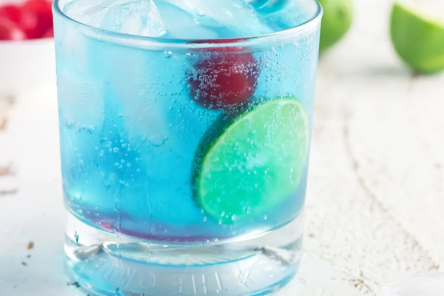 Red White and Blue Drink Recipes with Alcohol Blue Gin and Tonic Cocktail Garnished with a Cherry and a Slice of Lime