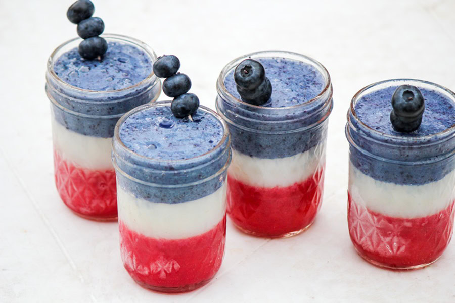 Red White and Blue Drinks 4th of July Smoothie in Small Mason Jar Glasses with Blueberry Garnishes