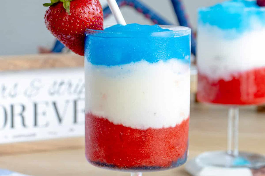 Red White and Blue Drinks Frozen Red, White & Blue Drink in a Glass with a Strawberry and a Straw