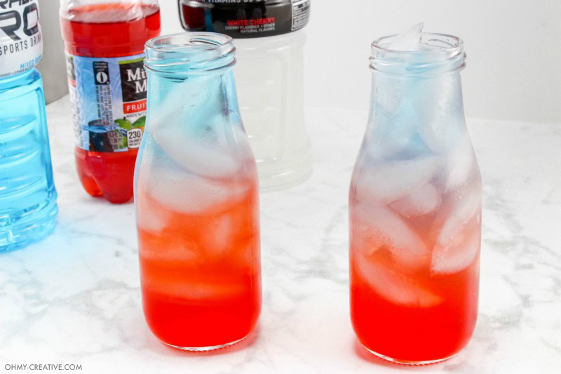 Red White and Blue Drinks Layered Red White And Blue Drink in Glass Milk Jugs with Ice
