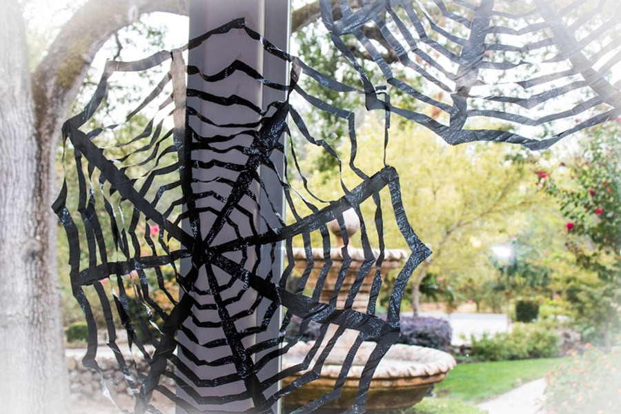 Halloween Decorations for a Spooky Party DIY Trash Bag Spiderwebs in a Window