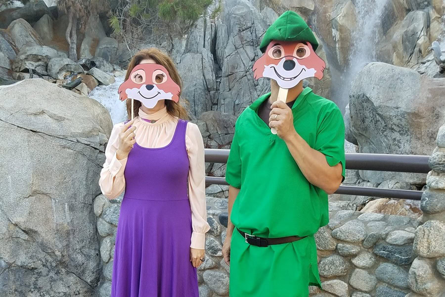 DIY Couple Halloween Costume Ideas a Man and Woman Dressed as Robin Hood and Marianne Holding Paper Masks in Front of Their Faces